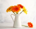 Beautiful bouquet of red and yellow flowers in white vase on wooden table, front view. Autumn still life with flowers Royalty Free Stock Photo