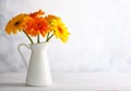 Beautiful bouquet of red and yellow flowers in white vase on wooden table, front view. Autumn still life with flowers Royalty Free Stock Photo