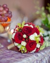 Beautiful bouquet of rose flowers on table. Wedding bouquet of red roses. Elegant wedding bouquet on table at restaurant