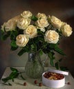 A beautiful bouquet of roses in a crystal jug and a box with tasty nuts. Royalty Free Stock Photo