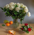 Beautiful bouquet of roses in a crystal jug and a pear with tangerines. Royalty Free Stock Photo