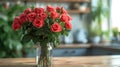 A beautiful bouquet of roses stands in a glass vase on a wooden table Royalty Free Stock Photo