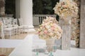 Beautiful bouquet of roses in a vase on a background of a wedding arch. Beautiful set up for the wedding ceremony Royalty Free Stock Photo