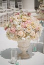 Beautiful bouquet of roses in a vase on a background of a wedding arch. Beautiful set up for the wedding ceremony. Royalty Free Stock Photo