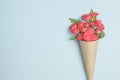 Beautiful bouquet of small red roses in vintage paper on the table. Royalty Free Stock Photo