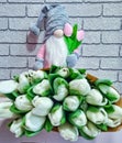 beautiful bouquet of spring flowers, toy nisse gnome with tulips, dwarf in grey hat