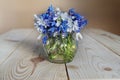 Beautiful bouquet of spring flowers in a vase with water on a table on a white background Royalty Free Stock Photo