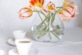 Bouquet of stripped white and red tulips and two cups of coffee on the table. Top view Royalty Free Stock Photo