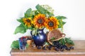 Beautiful bouquet of sunflowers in a vase and black currant berries. Still life with flowers and berries Royalty Free Stock Photo