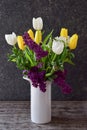 A beautiful bouquet of tulips and lilacs in a white vase, side view Royalty Free Stock Photo