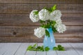 Beautiful bouquet of white hydrangea flowers in a vase on a wooden background Royalty Free Stock Photo
