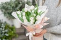 Beautiful bouquet of white tulips flowers in woman hand. the work of the florist at a flower shop. cute lovely girl Royalty Free Stock Photo