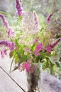 A beautiful bouquet of wild flowers on a wooden surface in the rays of the setting sun. Summer, nature, beauty. Vertical Royalty Free Stock Photo