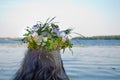 Beautiful bouquet of wreath of wild flowers on the head of a girl near the water river Royalty Free Stock Photo