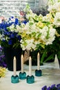 Beautiful bouquets with small matthiola flowers in the interior with candles on the table. Interior of the pavilion for the sale