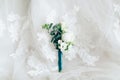 Beautiful boutonniere on white wedding dress, closeup