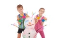 Beautiful boy and girl with hands in paint near color snowman with colored horns and hands Royalty Free Stock Photo