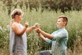 Beautiful boy and girl in a park, boy giving flowers to the girl. Friendship concept Royalty Free Stock Photo