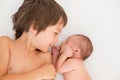 Beautiful boy, hugging with tenderness and care his newborn baby brother at home Royalty Free Stock Photo