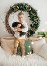 Beautiful boy near a Christmas tree with gifts feeding Royalty Free Stock Photo