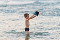 Beautiful boy playing with a bucket toy in the sea Royalty Free Stock Photo