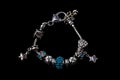 Beautiful bracelet with charms isolated on black background Royalty Free Stock Photo