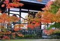 Beautiful branches of maple trees with red leaves in autumn on a photo of an ancient Japanese temple