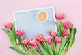 Beautiful breakfast with cup of coffee, spring tulip flowers and frame for good morning on pink pastel table top view in flat lay