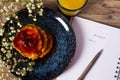 Beautiful Breakfast. Pancakes with jam and orange juice. Flowers and stylish dishes. Daily planner with the words Breakfast and