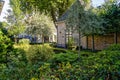 Beautiful brick house surrounded by trees, green plants and flowers in a garden Royalty Free Stock Photo