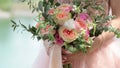 Beautiful bridal bouquet in hands of the bride. Wedding bouquet of peach roses by David Austin, single-head pink rose aqua,