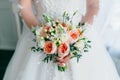 Beautiful bridal bouquet with white roses and peach peonies in a bride hands in white dress. Wedding morning. Close-up Royalty Free Stock Photo