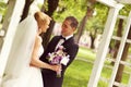 Beautiful bridal couple having fun in the park on their wedding day flower bouquet Royalty Free Stock Photo