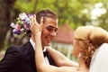 Beautiful bridal couple having fun in the park on their wedding day flower bouquet Royalty Free Stock Photo