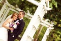 Beautiful bridal couple having fun in the park on their wedding day flower bouquet Royalty Free Stock Photo