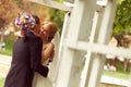 Beautiful bridal couple having fun in the park on their wedding day flower bouquet