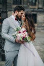 Beautiful bride and groom embracing and kissing on their wedding day outdoors Royalty Free Stock Photo