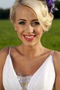 Beautiful bride blond blue eyes green field Royalty Free Stock Photo