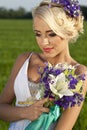 Beautiful bride blond blue eyes green field Royalty Free Stock Photo