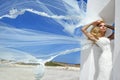 Beautiful bride blonde female model in amazing wedding dress poses on the island of Santorini in Greece