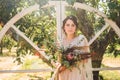Beautiful bride with bouquet flowers stands on forest background. Rustic style. beautiful bride in delicate dress outdoors. Close Royalty Free Stock Photo