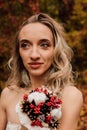 Beautiful bride with a bouquet in her hands. Wedding in autumn in the forest