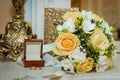 Beautiful bride bouquet with yellow roses, white flowers and gold rings with a crust on the wedding day Royalty Free Stock Photo