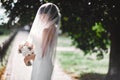 Beautiful bride in bridal gown with bouquet and lace veil on the nature. Beautiful model girl in a white wedding dress Royalty Free Stock Photo