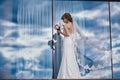 Beautiful bride in bridal gown with bouquet and lace veil on the nature. girl in a white wedding dress. Female portrait Royalty Free Stock Photo