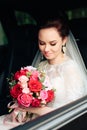 Beautiful bride in the car with a wedding bouquet 1 Royalty Free Stock Photo