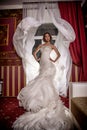 Fashion vogue photo beautiful bride with curly hair in a gorgeous wedding dress with precious perfect poses in amazing interior Royalty Free Stock Photo