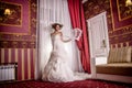 Fashion vogue photo beautiful bride with curly hair in a gorgeous wedding dress with precious perfect poses in amazing interior Royalty Free Stock Photo