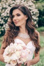 Beautiful bride with dark hair in luxurious wedding dress with tender wedding bouquet Royalty Free Stock Photo