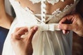 Beautiful bride dress. Witness tying a bow wedding dress on the bride Royalty Free Stock Photo